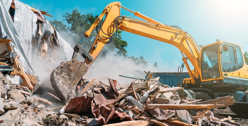 Demolition of building. Excavator breaks old house.